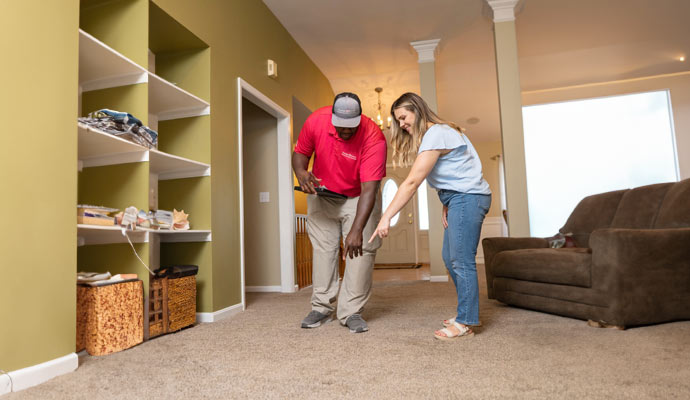 Professional inspecting damaged carpet